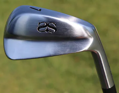 Miura forged irons displayed on a workbench